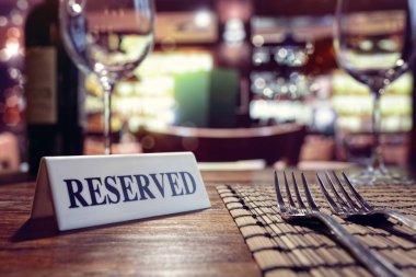 Restaurant reserved table sign with places setting and wine glasses ready for a party clipart