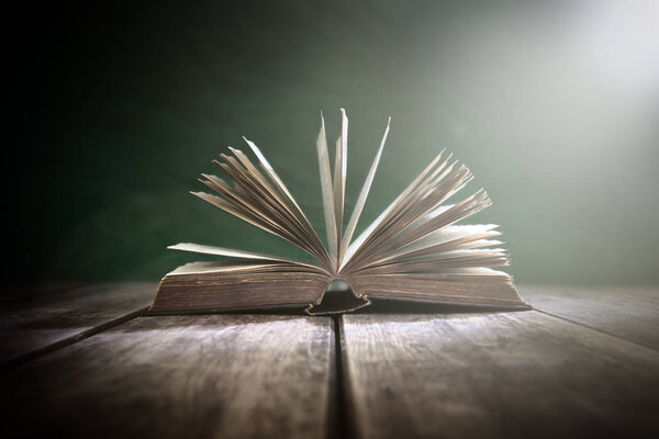 Old book or open Holy Bible on a table with spot light