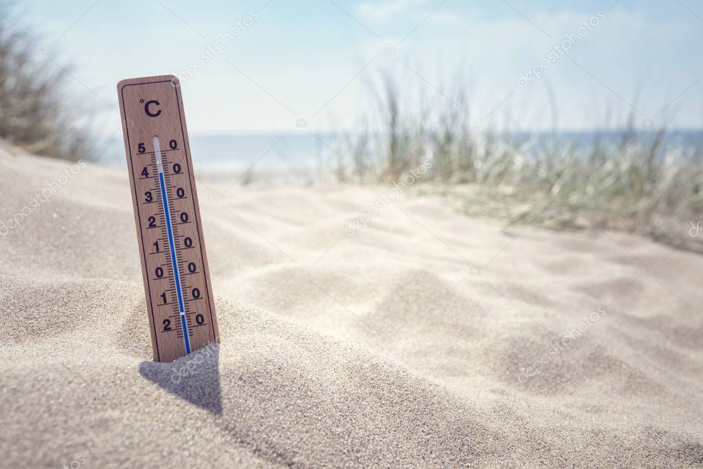Thermometer on the beach showing high temperature  background