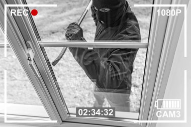 CCTV view of burglar breaking in to home through window with crowbar clipart
