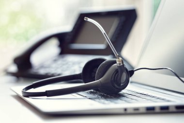 VoIP kulaklık kulaklık kavramı iletişim için telefon ve dizüstü bilgisayar, destek, çağrı merkezi ve müşteri hizmet yardım masası