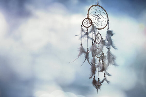Dreamcatcher on blue background with copy space