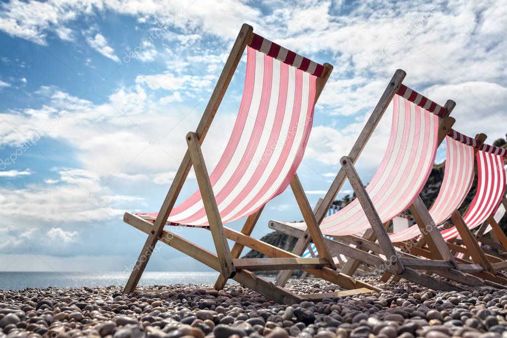 Deck chairs on the beach at the seaside on summer vacation