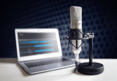 Podcast mikrofon ve dizüstü bilgisayar kayıt stüdyosunda masada
