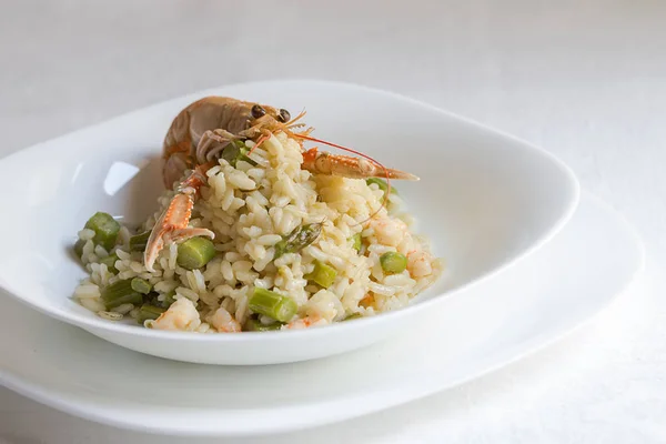 risotto with shrimps and asparagus, white background close-up