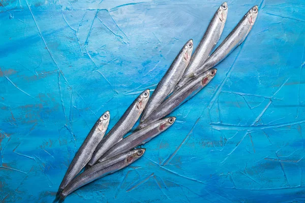 Padrão de peixe Um grupo de anchovas está flutuando sobre um fundo azul. Peixes capturados no mar Jónico — Fotografia de Stock