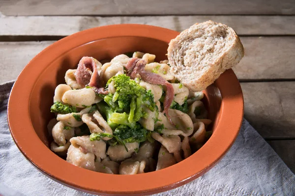 Apulia Bölgesi makarna Orecchiette şalgam ve salamura hamsi, yakın çekim, rustik tarzı ile geleneksel çanak