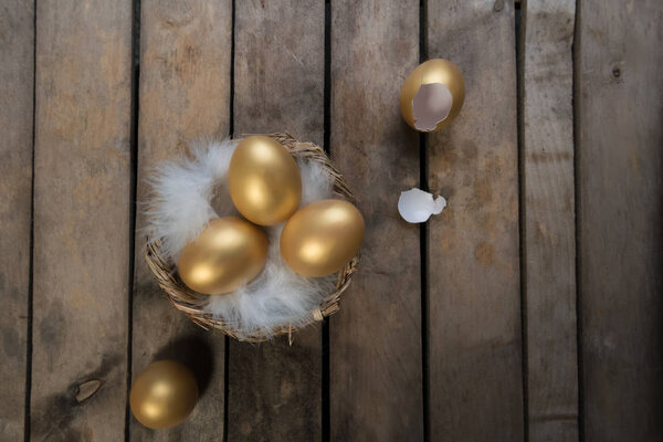 Success Symbol or Happy Easter Concept. Empty Broken Big Golden Egg on a rustic wooden natural background, top view