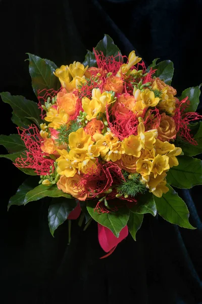 Buquê de férias fresco primavera de freesias amarelas e rosas em um fundo preto, orientação vertical — Fotografia de Stock