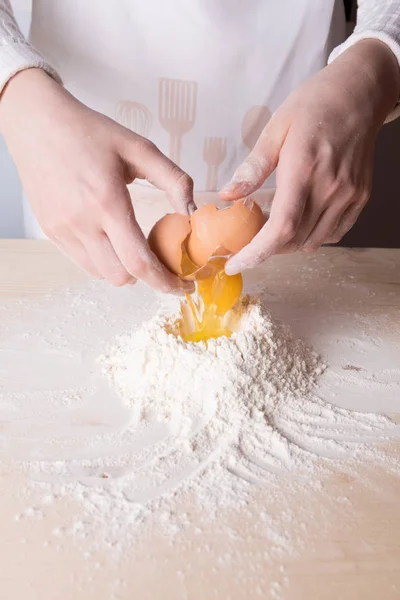 이탈리아 파스타, 라비올리 또는 두 반죽을 만들기 위해 흰 밀가루 위에 젊은 여자 휴식 계란 — 스톡 사진