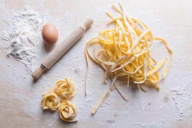 Ahşap masa, İtalyan ham ev yapımı makarna tagliatelle. İtalyan makarna un, su ve yumurta yapılmış.