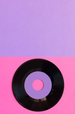İki tonluk Kağıt arka planda bir eski vinil disk: pembe ve menekşe, pop kültürü. Üst görünüm. Minimalizm, kopya alanı ile üst görünüm
