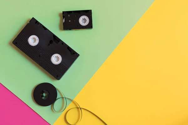 Retro video kassett och film på en tre-färg pastellfärgad papper bakgrund. Platt låg, minimalt koncept — Stockfoto