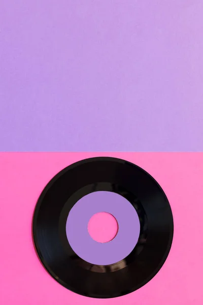 İki tonluk Kağıt arka planda bir eski vinil disk: pembe ve menekşe, pop kültürü. Üst görünüm. Minimalizm, kopya alanı ile üst görünüm — Stok fotoğraf