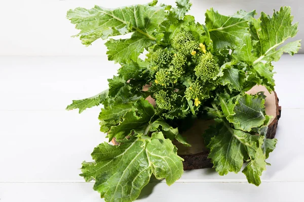 Raw Organic Turnip Greens Ready to Eat on a white wooden background, close up