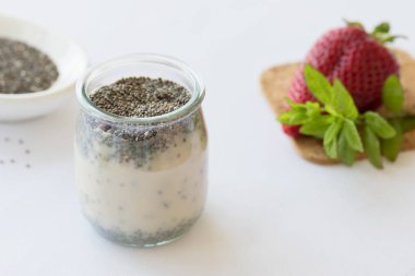 Masada taze çilek ile bir kavanozda Sağlıklı vegan chia puding