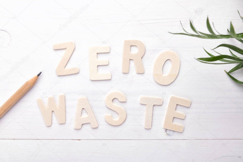 text zero waste with green leaves on white background