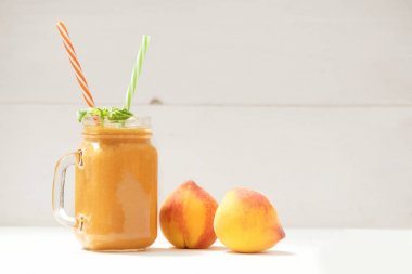 Sağlıklı yaz içecek, beyaz ahşap arka plan üzerinde taze harmanlanmış şeftali smoothie