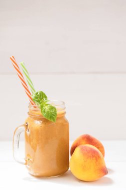 Sağlıklı yaz içecek, beyaz ahşap arka plan üzerinde taze harmanlanmış şeftali smoothie