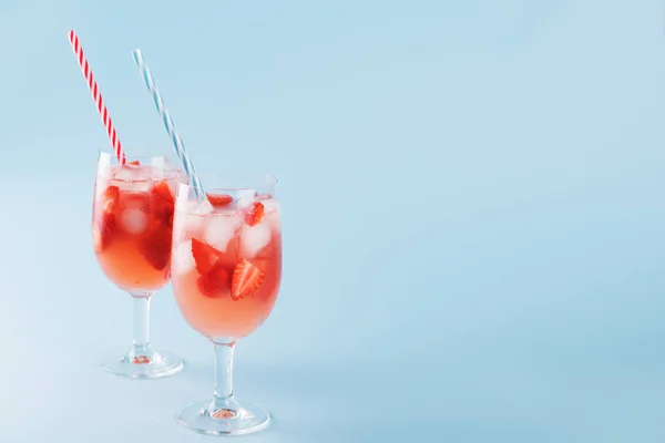新鲜的草莓夏季鸡尾酒和冰块。两杯草莓，冰和葡萄酒 - 草莓桑格里亚在柔和的蓝色背带，极简主义 — 图库照片