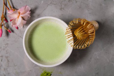 Gri mermer arka planda organik yeşil matcha çay içeceği ve çay aksesuarları. Japon çay töreni kavramı, düz yatıyordu