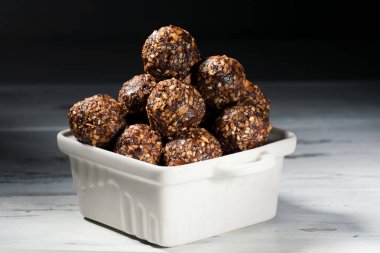 Haddelenmiş yulaf, fındık, hurma ve susam, yatay, yakın ile Ham ev yapımı paleo enerji topları