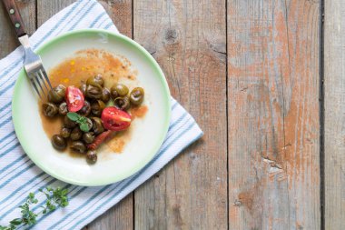 Lezzetli Apulian salyangoz domates soslu munaceddi denilen, ahşap bir arka plan üzerinde kekik, yakın ve kopya alanı, Salento gıda.