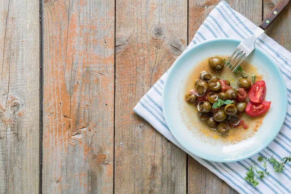 Pyszne ślimaki Apulian zwane munaceddi z sosem pomidorowym, oregano na drewnianym tle, zbliżenie i przestrzeń kopiowania, Salento żywności. — Zdjęcie stockowe