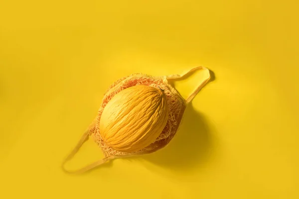 Свіжа жовта диня у ватному мішку на жовтому фоні — стокове фото