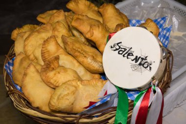 Avetrana, İtalya, 30 Ağustos 2019. Puglia yemeği: Panzerotti adı verilen bir sepette kızartılmış turtalar, Salento 'nun tefi ile yakın plan.