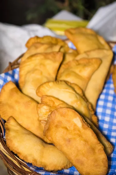 Apulian food: fried pies called panzerotti in a basket, made with tomato sauce, mozzarella and prosciutto, close-up