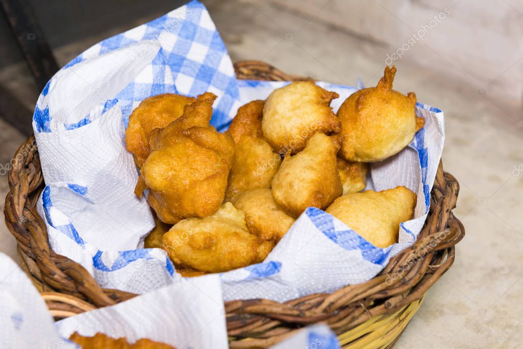 Pettole, Italian donuts fried in oil on a paper napkin in a basket. Made in Puglia. Served as an appetizer or with icing sugar as a Christmas dish