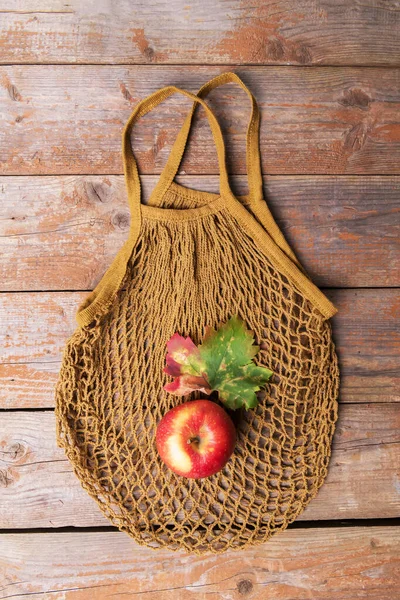 Autumn ecology flat lay: brown string bag of cotton with one red