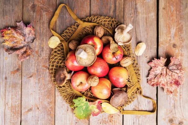 Manzanas de otoño, nueces, hongos cardoncelli en un eco de malla de algodón — Foto de Stock