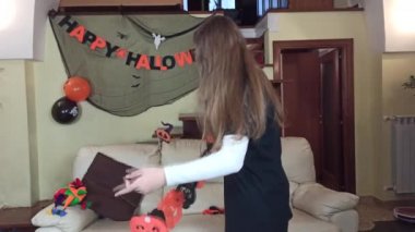 Kağıt maske yapan bir kız, Cadılar Bayramı için evde hazırlan, Cadılar Bayramı 'nı evde şenlikli süslerle kutla.