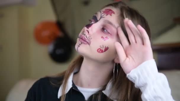 一个女孩展示她自己万圣节的化妆圣穆埃尔或糖墨西哥骷髅 在家里庆祝万圣节 — 图库视频影像