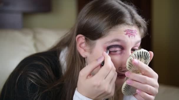 女の子はサンタ ムエルテやメキシコの砂糖の頭蓋骨の化粧をして ハロウィンを祝う準備をします ハロウィンを家で祝う — ストック動画