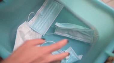 Koronavirüs salgını sırasında tıbbi koruyucu maskeleri yıkayan bir kadının elini kapatın. Covid-19 salgınında tek kullanımlık maskelerin yeniden kullanılması normaldir.