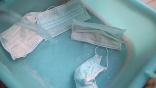 清洗医疗防护面罩 水倒入蓝色的洗脸盆 洗衣粉倒入 Coronavirus Covid 19大流行期间的新常态 — 图库视频影像
