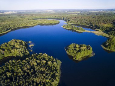 Havadan görünümü küçük ıssız ada (Wyspa Pozeracza Serc) ile gökyüzü göl kenarında sakin su, Krzywa Kuta Gölü, Mazury, Polonya yansıyan