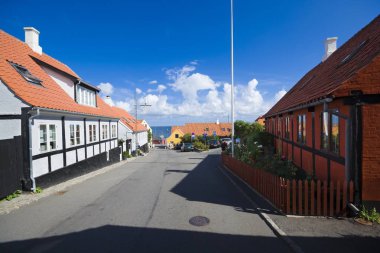 Gudhjem, Danimarka - 21 Ağustos 2018: Geleneksel renkli yarı ahşap ev liman doğru Bornholm önde gelen sokak