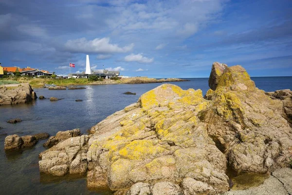 Kayalık sahil, Baltık Denizi Allinge, Bornholm, Denmark içinde. Keşhanede eşek muhabbeti kol arka planda baca.