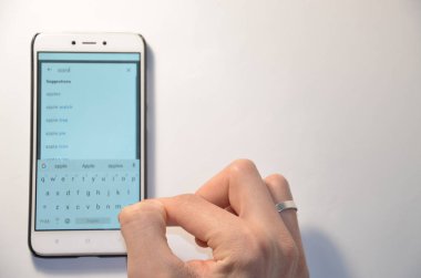 26 Şubat 2019. Kiev, Ukrayna. Beyaz zemin üzerinde bir akıllı telefon programıdır. Ellerini kullanarak smartphone üzerinde çalışmak