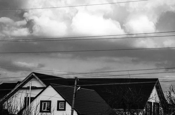 Foto em preto e branco do céu com nuvens por cima do edifício — Fotografia de Stock