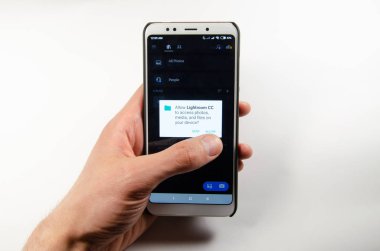 Nisan, 2019. Kramatorsk, Ukrayna. Mobil uygulama Lightroom elinde beyaz bir akıllı telefon