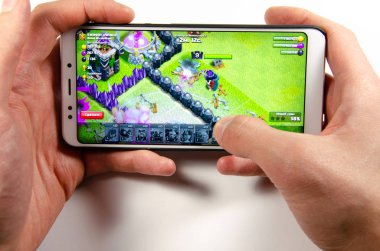 Nisan, 2019. Kramatorsk, Ukrayna. Klan oyun elinde beyaz bir smartphone üzerinde çatışması