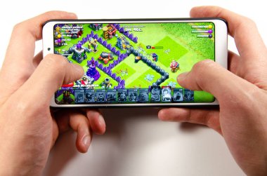 Nisan, 2019. Kramatorsk, Ukrayna. Klan oyun elinde beyaz bir smartphone üzerinde çatışması