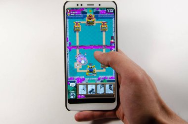 Nisan, 2019. Kramatorsk, Ukrayna. Royale oyun üzerinde beyaz bir akıllı telefon elinde çatışma