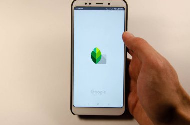 Nisan, 2019. Kramatorsk, Ukrayna. Elinde beyaz bir smartphone cep telefonu ile Snapseed mobil uygulama