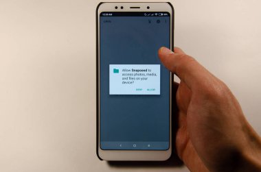 Nisan, 2019. Kramatorsk, Ukrayna. Elinde beyaz bir smartphone cep telefonu ile Snapseed mobil uygulama